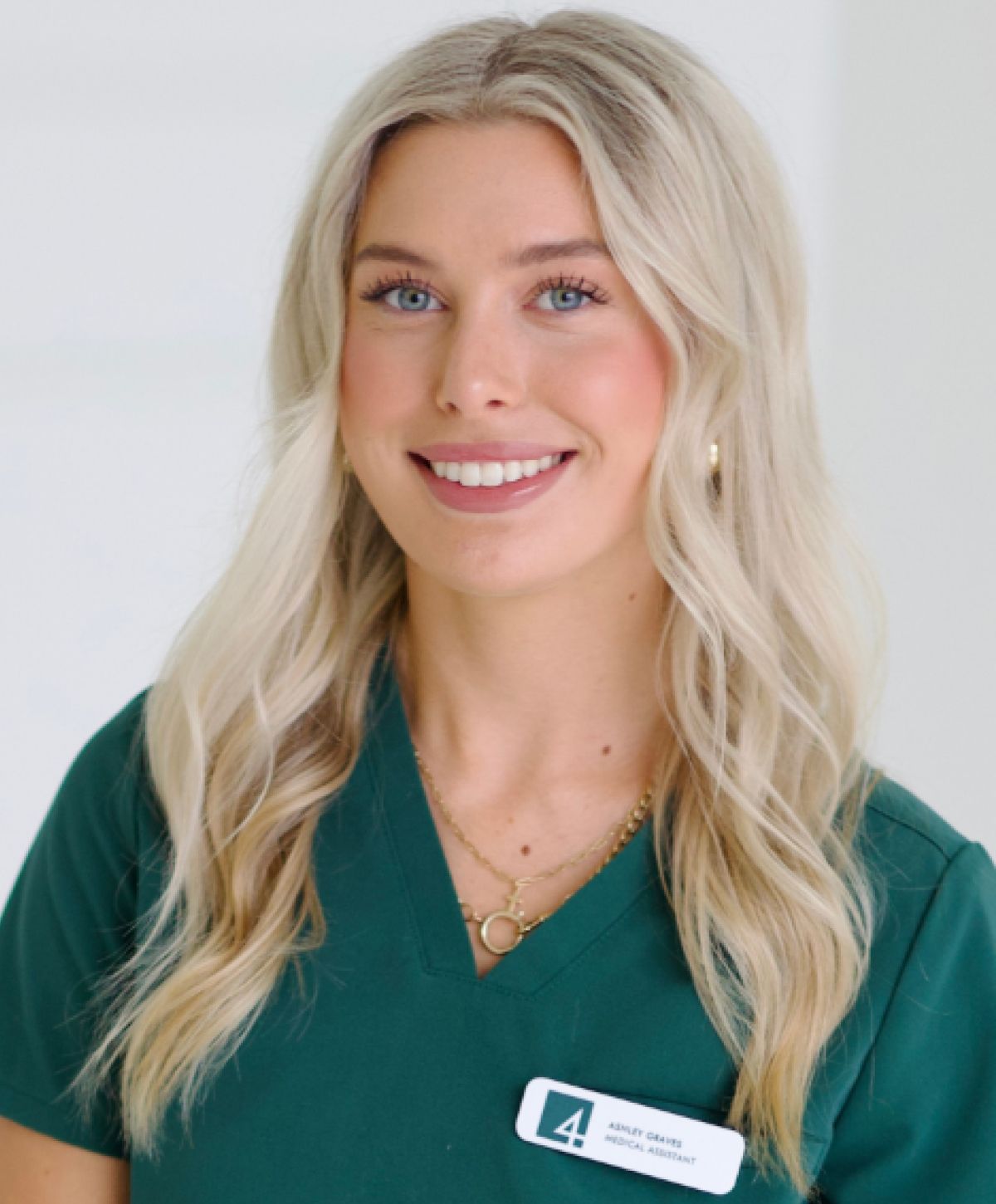 Smiling medical assistant in scrubs.