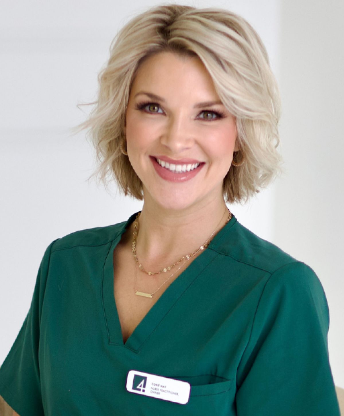 Smiling healthcare professional in green scrubs.
