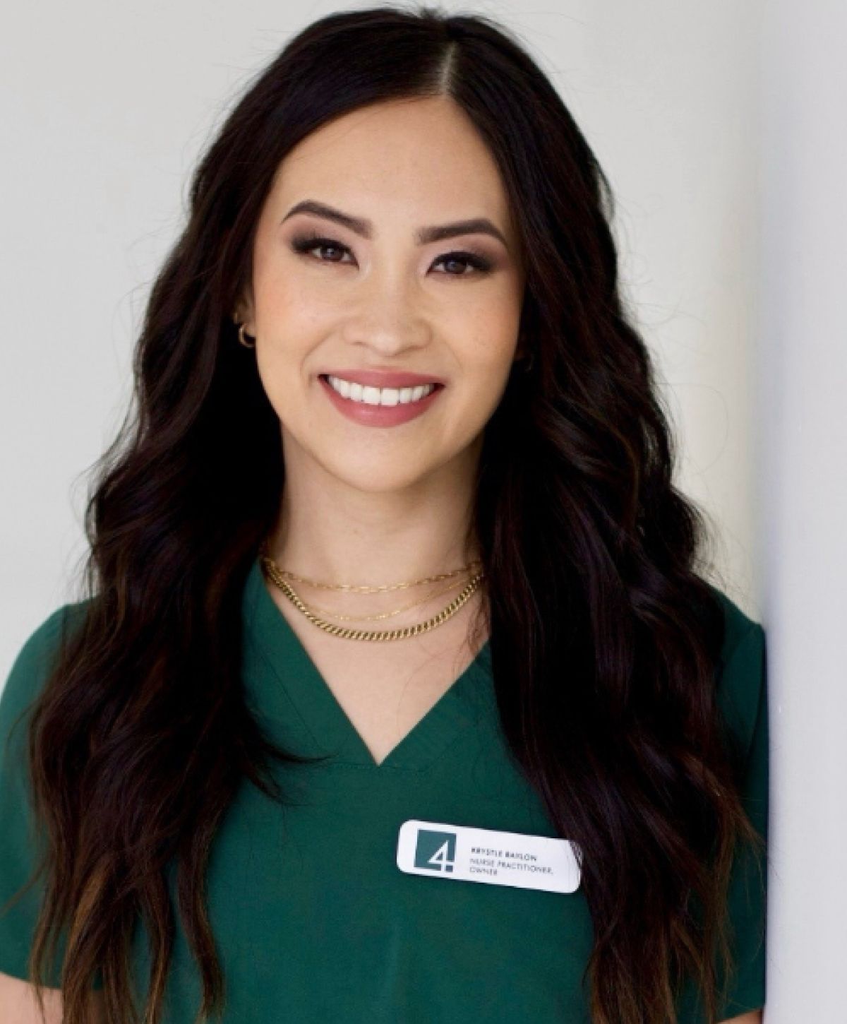 Smiling healthcare professional in green scrubs.