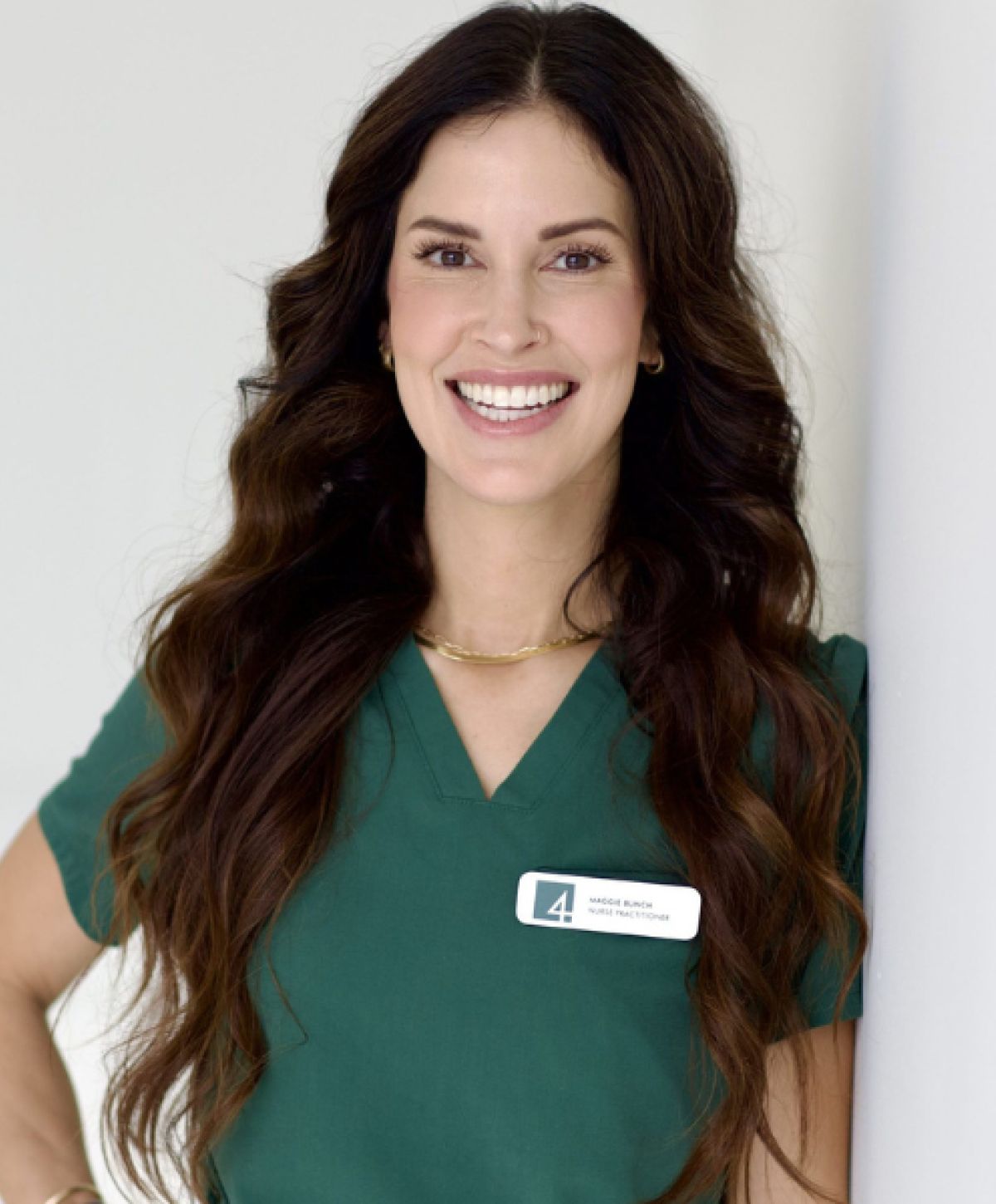 Smiling healthcare professional in green scrubs.