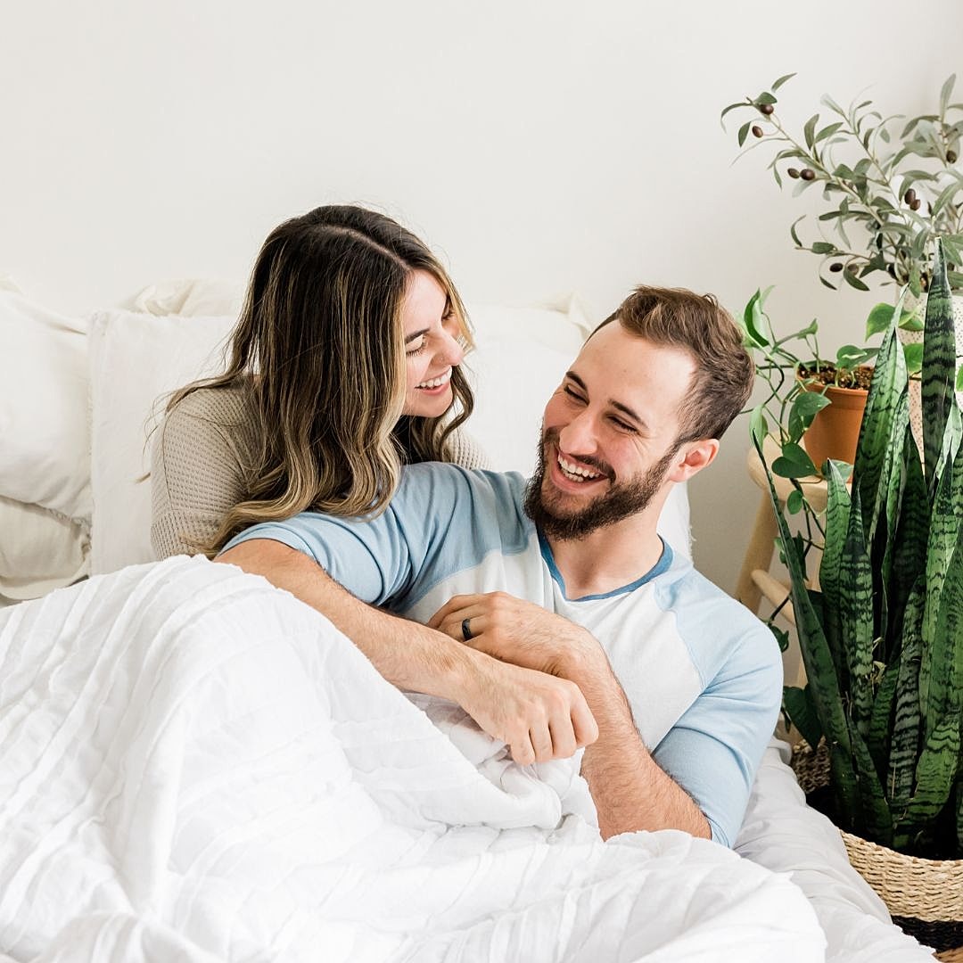 Couple happily sharing a moment in bed.